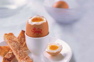 A boiled egg with a British Lion egg mark served on a plate with toast soldiers